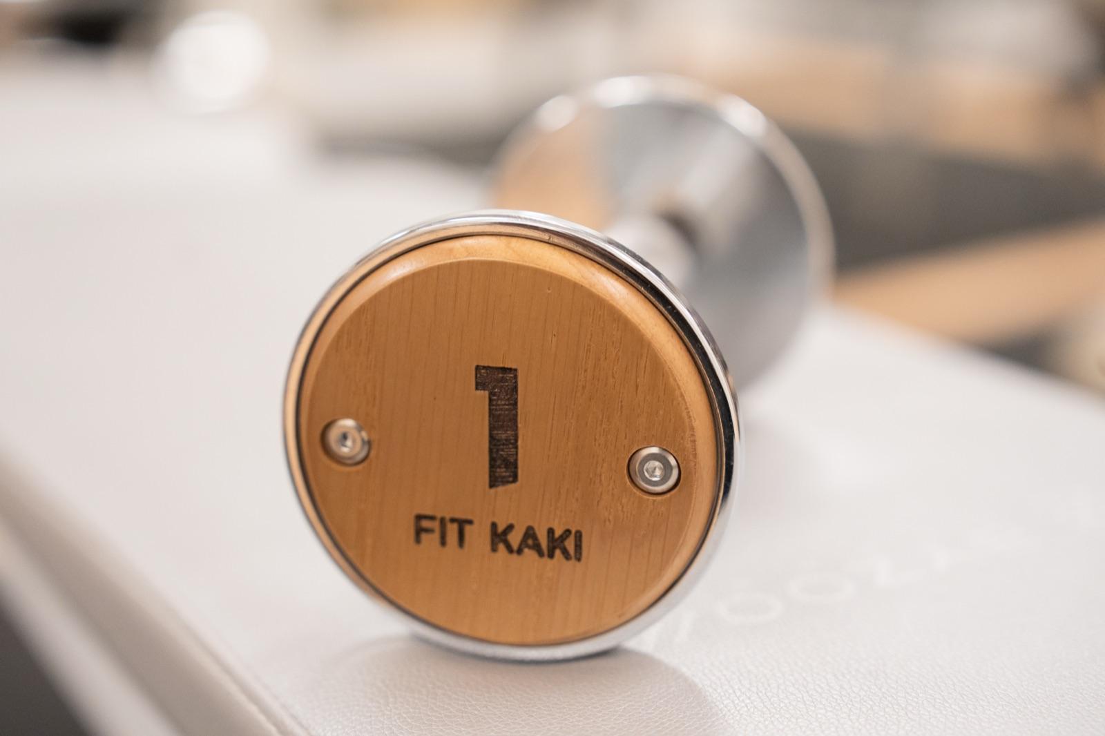 A Fit Kaki wooden dumbbell resting on a training bench at the Eunos studio