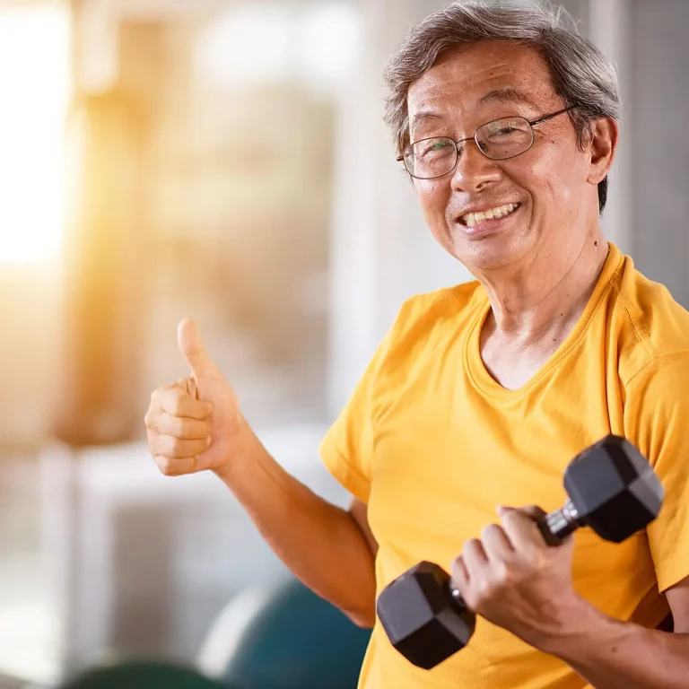 Elderly man lifting dumbbell in the gym