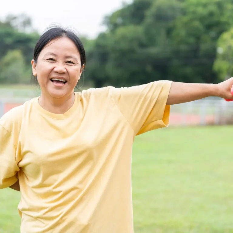 portrait fresthy mature adult woman enjoy doing exercise with dumbbell in the stadium,happily,laughing and looking at camera